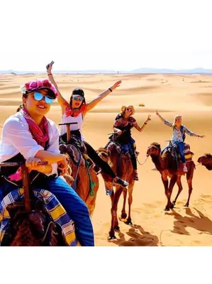 a group of people riding horses in the desert at Merzouga white camp in Merzouga