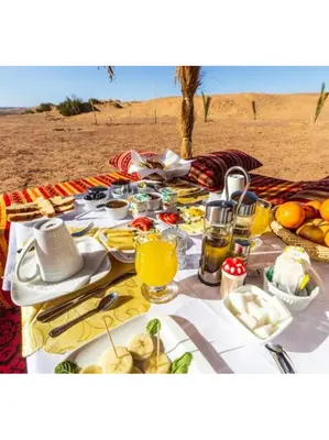 a table with food and drinks on the beach at Merzouga white camp in Merzouga