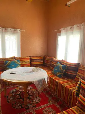 a living room with a couch with a table on it at Kasbah in El Hart