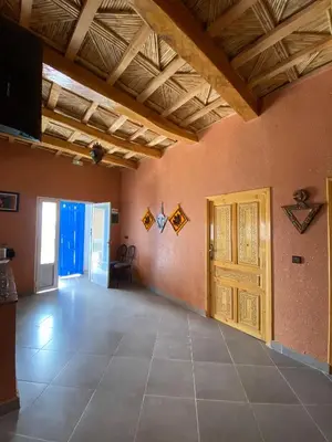 a large living room with a wooden ceiling at Kasbah in El Hart
