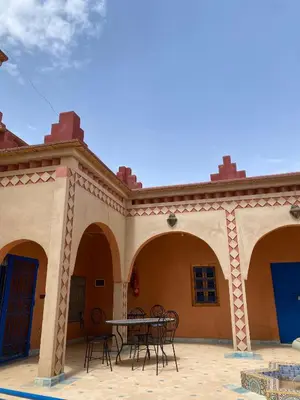 a patio with chairs and a table in front of a building at Kasbah in El Hart