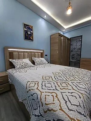 a bedroom with a large bed and a blue wall at La maison bleu in Oulad Akkou
