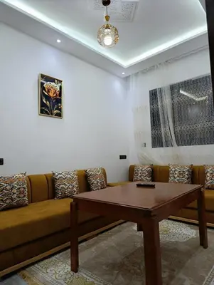 a living room with a couch and a table at La maison bleu in Oulad Akkou