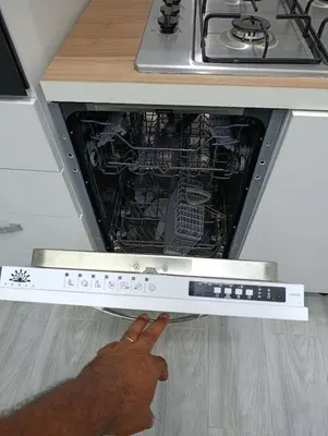 a person reaching into an oven with their hand at La maison bleu in Oulad Akkou