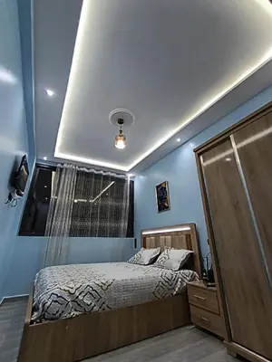 a bedroom with a bed and a window at La maison bleu in Oulad Akkou