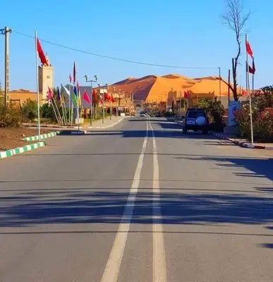 an empty road in the middle of a desert at visitando el desierto in Merzouga