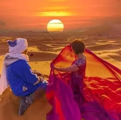 a painting of two women on the beach at sunset at visitando el desierto in Merzouga