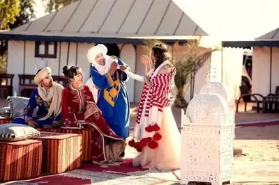 a group of people dressed in costumes standing next to a woman at visitando el desierto in Merzouga