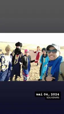 a group of people standing on the beach at visitando el desierto in Merzouga