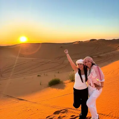 two women standing in the desert at sunset at Luxurious magic camp in Merzouga