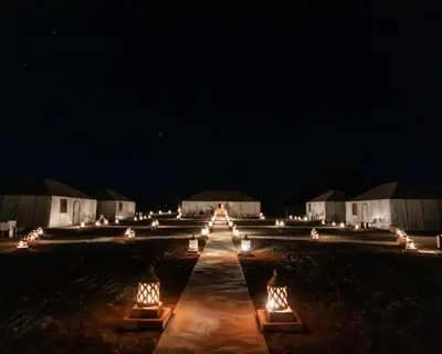 a row of lights in a field at night at Luxurious magic camp in Merzouga