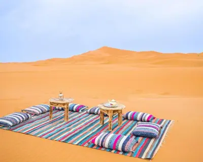 two tables on a blanket in the desert at Luxurious magic camp in Merzouga