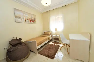 a bedroom with a bed and a desk in it at Tifawt in Oulad Akkou
