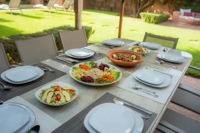 a table with plates and bowls of food on it at Luxueuse villa VALERIA avec gouvernante in Chaibate
