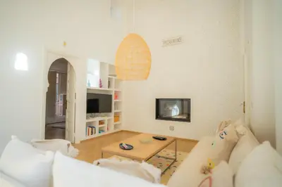 a living room with a couch and a tv at Luxueuse villa VALERIA avec gouvernante in Chaibate