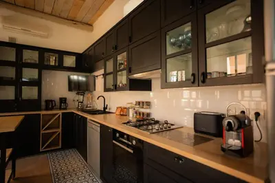 a kitchen with black cabinets and a counter top at Luxueuse villa VALERIA avec gouvernante in Chaibate
