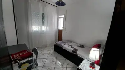 a bedroom with a bed and a table and a window at Appartement in Oulad Akkou