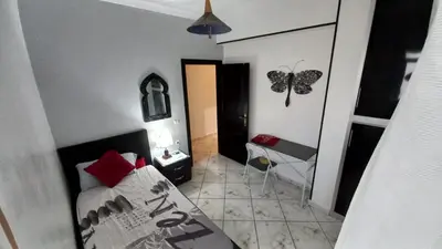 a bedroom with a bed and a butterfly on the wall at Appartement in Oulad Akkou