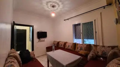 a living room with a couch and a table at Appartement in Oulad Akkou