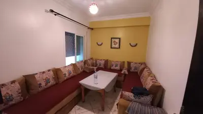 a living room with a couch and a table at Appartement in Oulad Akkou