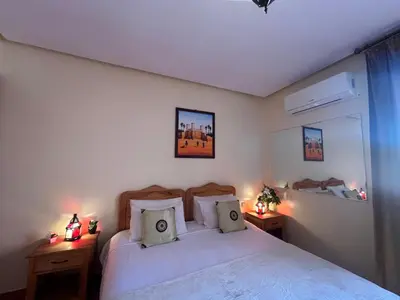 a bedroom with a white bed with two night stands at Villa Essalah & Spa Marrakech in Marrakech