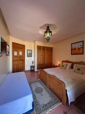 a bedroom with two beds and a chandelier at Villa Essalah & Spa Marrakech in Marrakech
