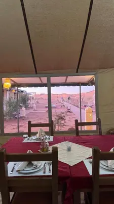 a dining table with a view of the desert at Tasnim Désert Camp & Activités in Merzouga
