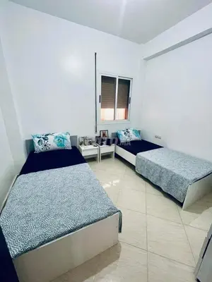 a bedroom with two beds in a room at Lot HABIBA in Khemisset