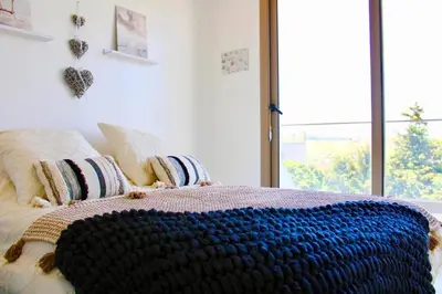 a bed with a blue crochet blanket on it at Maison avec 2 piscines vue mer et montagne in Oulad Akkou
