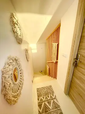 a room with a hallway with a door and a rug at Maison avec 2 piscines vue mer et montagne in Oulad Akkou