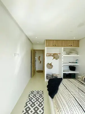 a bedroom with a bed and a white wall at Maison avec 2 piscines vue mer et montagne in Oulad Akkou