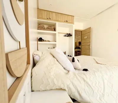 a bedroom with a bed with white sheets and pillows at Maison avec 2 piscines vue mer et montagne in Oulad Akkou
