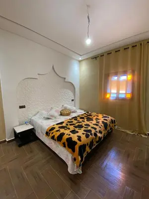 a bedroom with a bed with a cow patterned blanket at Villa cherif in Chouiter