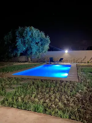 a swimming pool at night with blue lighting at Villa cherif in Chouiter