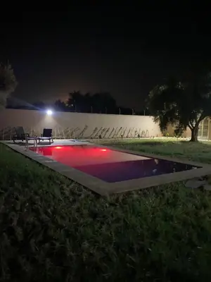 a swimming pool at night with a table and chairs at Villa cherif in Chouiter
