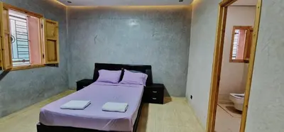 a bedroom with a bed with two towels on it at DAR MORAD VILLA AVEC PISCINE PRIVEE DANS UNE FERMe in Bou Azza