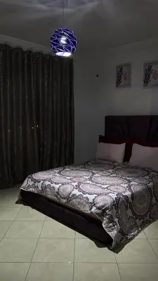 a bedroom with a bed with a comforter on it at Appartement BM - Béni Mellal in Beni Mellal