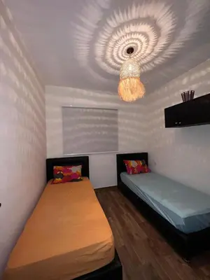 a room with two beds and a chandelier at Bella vesta in Oulad Akkou