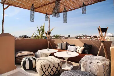 a patio with two tables and chairs on a roof at Dar Maya Original Suite & Spa in Fès