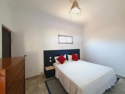 a bedroom with a large white bed with red pillows at Riad Elbahi in Marrakech