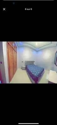 a bedroom with a blue bed in a room at Apparemment bien entretenu in Meknès