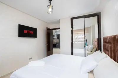 a bedroom with a white bed and a mirror at Basharly in Oulad Akkou