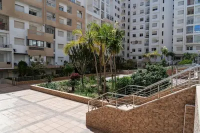 a courtyard in a building with palm trees and buildings at Basharly in Oulad Akkou
