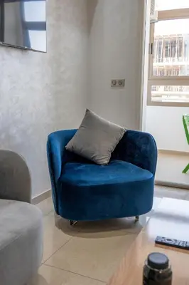 a blue chair with a pillow in a living room at Basharly in Oulad Akkou