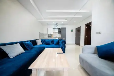 a living room with a blue couch and a table at Basharly in Oulad Akkou