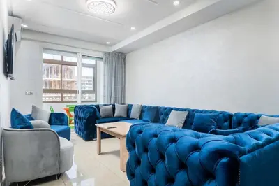 a living room with a blue couch and chairs at Basharly in Oulad Akkou