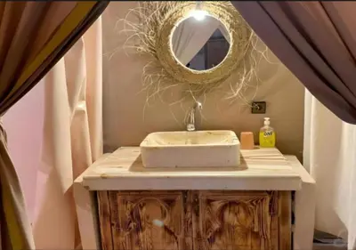 a bathroom with a sink and a mirror on a counter at Sahara Luxurious Tented in Merzouga