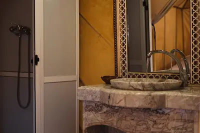 a bathroom with a sink and a mirror at Sahara Luxurious Tented in Merzouga