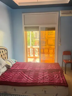a bedroom with a bed with a red blanket on it at Petite villa à cap de l eau in Oulad Akkou