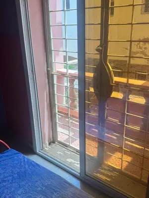 a cat is looking out of a window at Petite villa à cap de l eau in Oulad Akkou